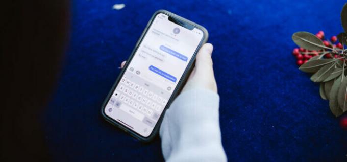 Persons hånd viser tekstbeskeder på mobiltelefon