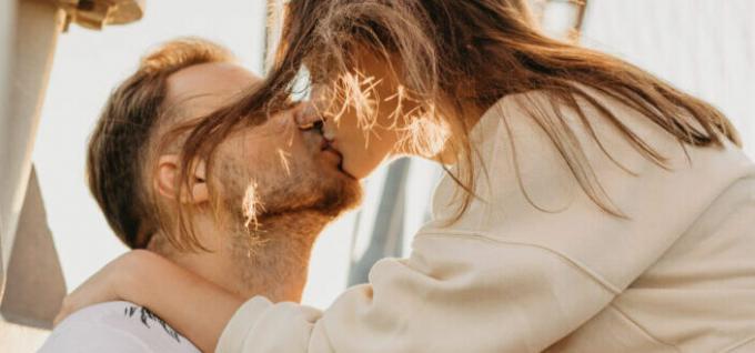 Романтическая пара целуется на улице в солнечном свете