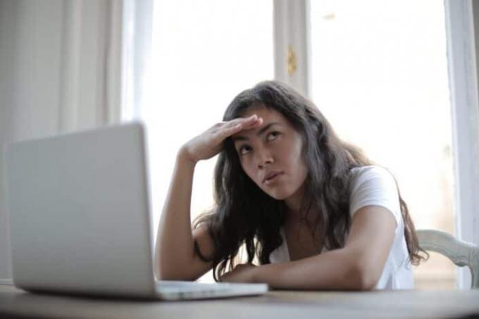 Giovane libera professionista femminile infastidita che utilizza il computer portatile a casa