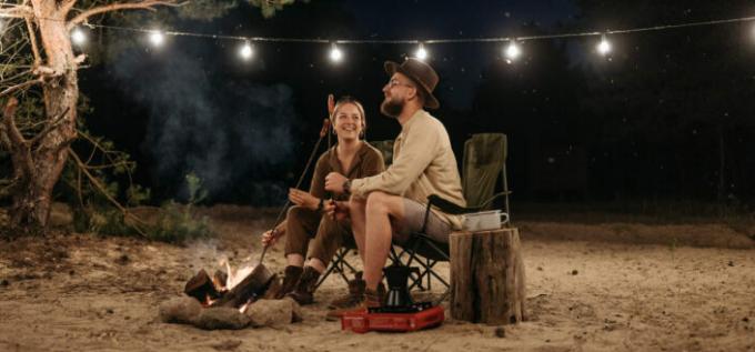Par sjedi na stolici dok roštilja na logorskoj vatri