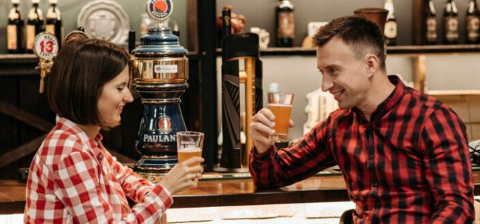 Ένας άνδρας και μια γυναίκα που κρατούν ποτήρια με μπύρα